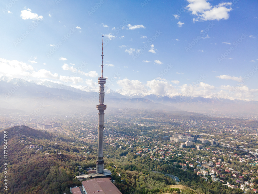 Fototapeta premium Late September in Almaty, a drone view of the Kok-Tobe TV tower. The city and mountains, yellowed grass and foliage are visible. An autumn landscape.