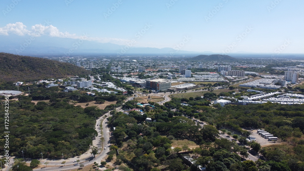 Naklejka premium Aerial drone view of valledupar city in Colombia, buildings in background and blue sky.