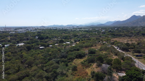 Aerial drone view of valledupar city in Colombia, mountains in background and blue sky. green areas