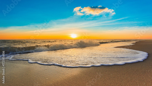 Beautiful sunrise on the beach with sea wave and cloud on sky