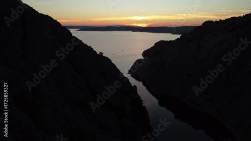 Aerial view of a dramatic canyon with turquoise water surrounded by rugged rocky cliffs. Zavratnica Bay in Croatia.