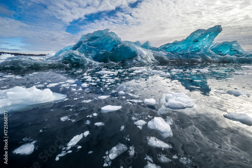 Blue Diamond Iceberg Floating in the Water with Dramatic Sky at Jökulsárlón Glacier Lagoon, Iceland.