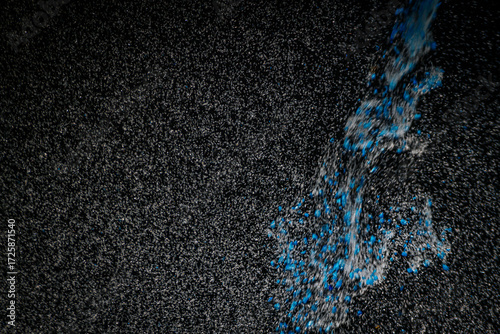 Abstract view of white and blue particles floating against a black background, resembling stars in space or underwater bubbles in darkness.