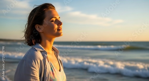 Young woman breathing fresh ocean air at sunset