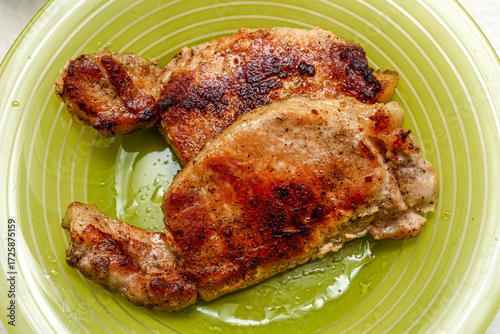 Top view of fried meat on a green plate.