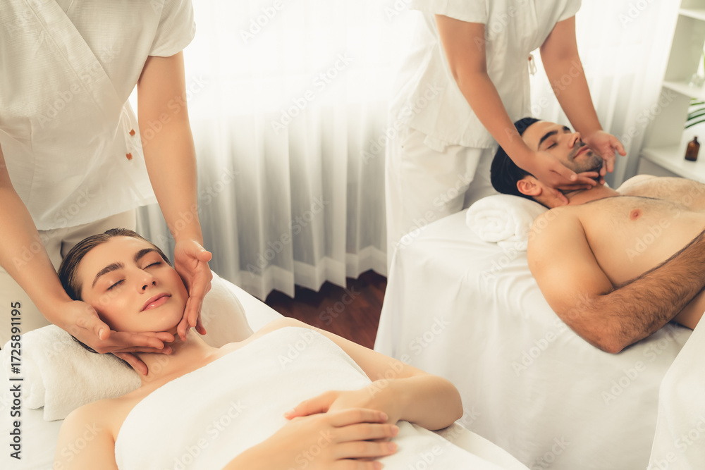 Obraz premium Caucasian couple enjoying relaxing anti-stress head massage and pampering facial beauty skin recreation leisure in dayspa modern light ambient at luxury resort or hotel spa salon. Quiescent