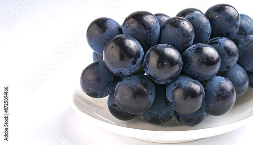 Dark grapes on white plate