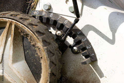Fotografía Close-up of a lawn mower adjustment dial with a dirty wheel