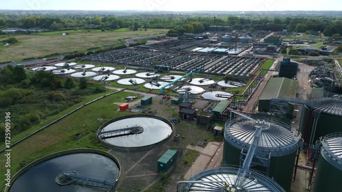 Aerial drone view of huge wastewater sewage plant treatment, circular clarifiers, filtration pools, storage silos, Trent water Leicester England UK