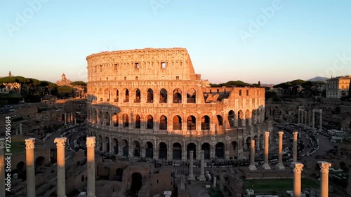 The iconic colosseum in rome, italy, stands tall amidst ancient ruins, bathed in the warm glow of the setting sun, showcasing its grandeur and history
