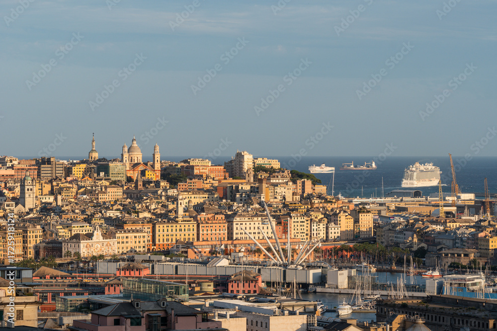 Obraz premium wide view to a Genoa center with cruise ship leaving port at sunset