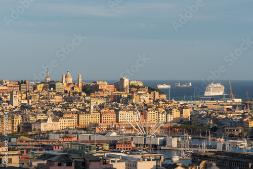 wide view to a Genoa center with cruise ship leaving port at sunset