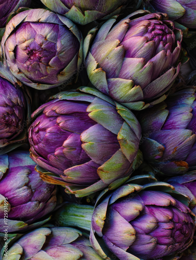 Obraz premium Freshly harvested artichokes with rich purple hues gathered in a market display during early morning hours in a vibrant farmer's market