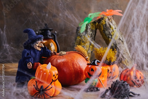 halloween, a cheerful witch rolls a big pumpkin to a noisy cobweb party with different pumpkins and spiders, All Saints Day, horizontal, creative focus