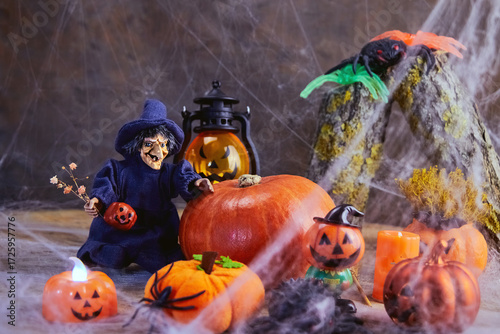 halloween, a cheerful witch with flowers stands near a big pumpkin at a noisy cobweb party with other pumpkins and spiders, All Saints Day, horizontal, creative focus