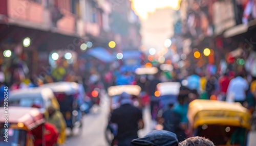 A blurry photo captures a busy street scene packed with people and vehicles. Buildings line the edges of the roadway, creating an energetic, bustling atmosphere
