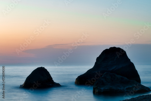 Close up view of the Black Sea at sunset in Georgia with rocks in the water, perfect for travel, tourism, and nature themes.