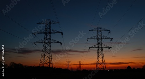 Silhouetted power pylons against a vibrant sunset sky, conveying energy and infrastructure.