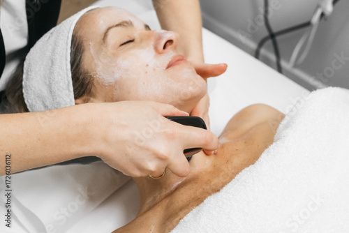 Φωτογραφία Woman receiving RF lifting treatment for facial rejuvenation, with a professiona