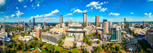 Daytime aerial view of downtown Atlanta skyline with parks, buildings, and clear skies
