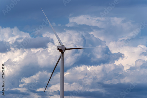 Rear view of wind turbine against dramatic storm clouds