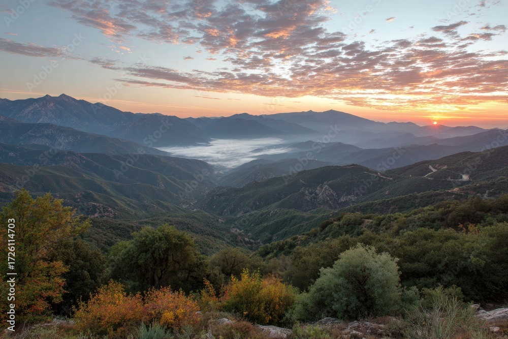 Fototapeta premium Mountain vista at sunrise, a valley shrouded in mist