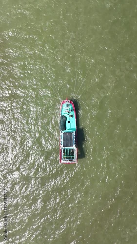 Aerial Perspective of Small Vessels Navigating Murky Green Water