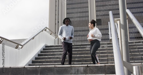 Diverse friends jogging down staircase, exchanging glance pivoting and running up steps for workout