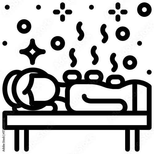 Lady enjoys a relaxing hot stone massage at the spa on a massage table.