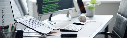 Photos Header of modern office workspace featuring desktop computer with code on screen