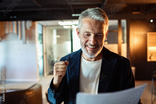 Happy businessman reading document