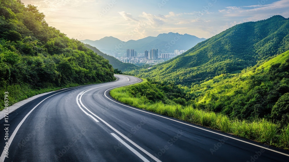 Naklejka premium A long asphalt highway winding through lush green mountains, on blurred background