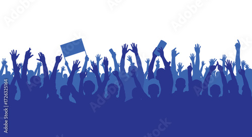 A diverse crowd of people celebrating with raised hands and a flag in the air.
