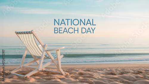 A beach chair on sandy shore with ocean waves and clear sky, celebrating National Beach Day
