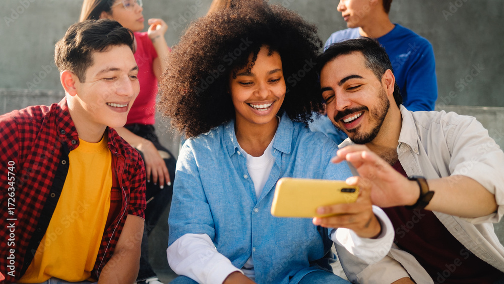 Obraz premium Young multiracial friends smiling and using smartphone outside school college. Youth lifestyle and technology concept