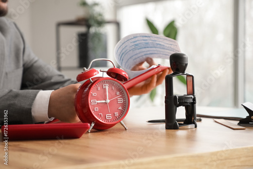 Red alarm clock on table ag...