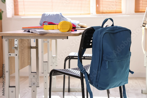 Blue backpack hanging on ch...
