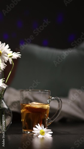 Relax with a warm cup of chamomile tea beside a glowing night light. This soothing herbal remedy helps ease insomnia and promotes restful sleep in a calming setting.