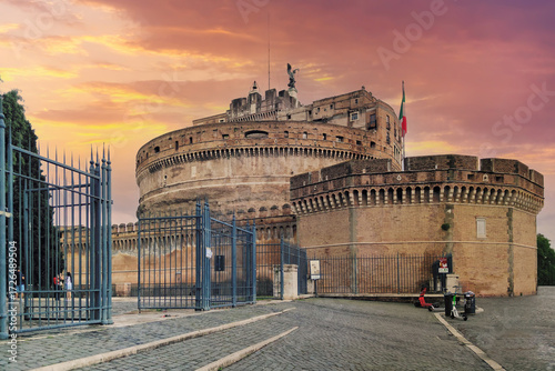 The historic Castel Sant'Angelo, also known as the Mausoleum of Hadrian, in Rome, Italy, illuminated by a beautiful and dramatic sunset sky, a famous ancient Roman landmark