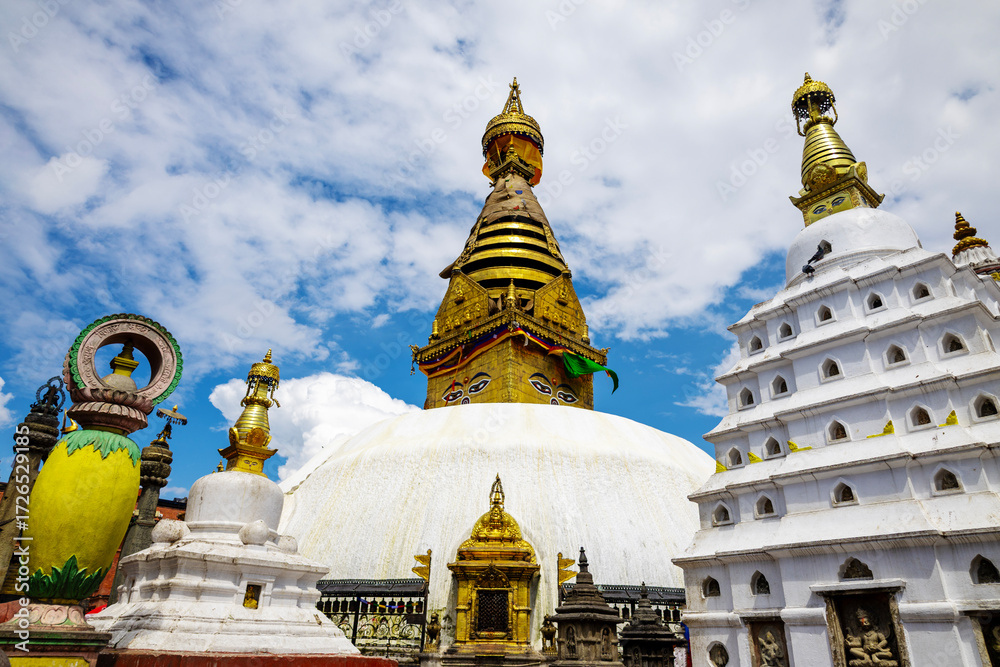 Fototapeta premium A stunning view of the golden Swayambhunath stupa in Nepal, adorned with intricate Buddhist symbols and surrounded by peaceful clouds. This UNESCO World Heritage site is a symbol of Nepalese spiritual