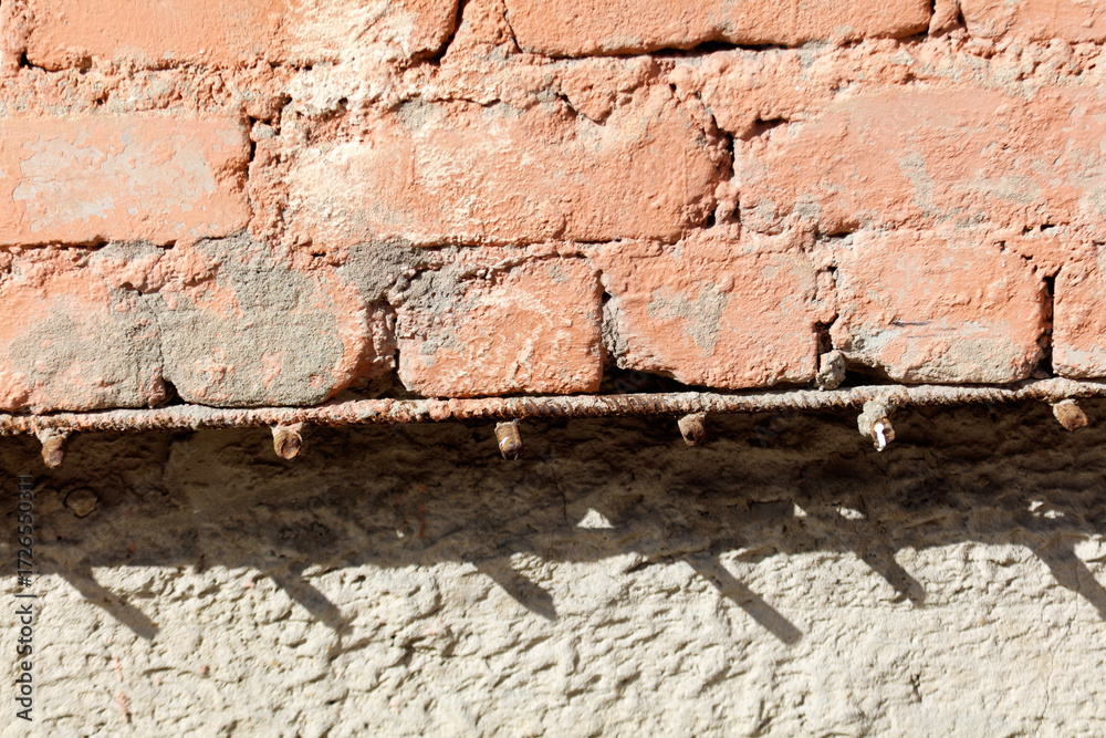Fototapeta premium A brick wall with a metal bar on the side