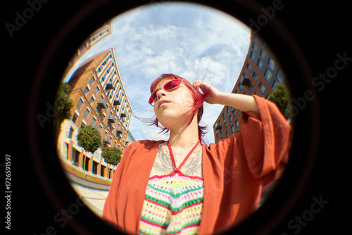 Bild auf Leinwand Young Caucasian woman standing outdoors tilting head back and touching hair, wea