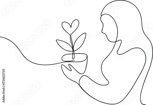 Woman in hijab holding potted plant with heart shaped leaves