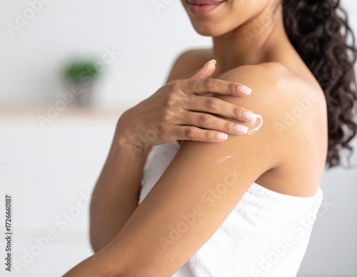 Woman applying lotion to her arm, promoting skincare and self-care.