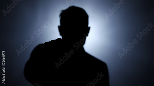 A stern-faced figure points an accusatory finger, casting a shadowy silhouette against a blurred background, conveying