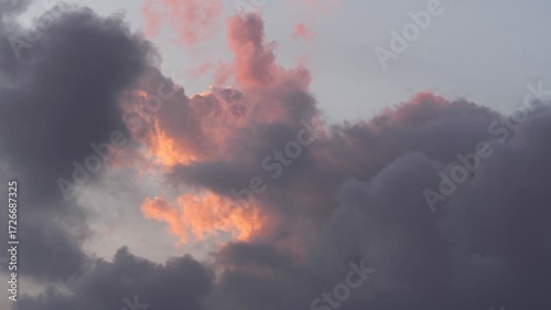 Dramatic clouds fill the sky with shades of gray and hints of orange. The scene captures a moody atmosphere during sunset.