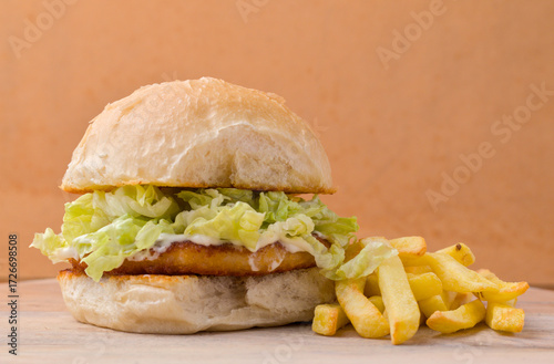 Chicken Burger with lettuce, mayonaise and a side of chips.