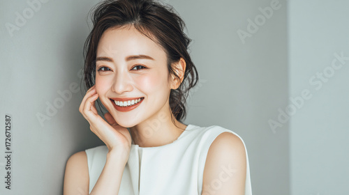 笑顔できらめく綺麗な肌と白い歯を見せる日本人女性美人モデルの接写写真。オーラルケア、スキンケア、コスメ広告用。