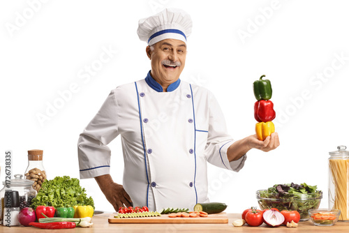 Male chef smiling and holding bell peppers
