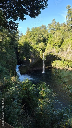 Stunning view of Saltos del Nilahue waterfall in southern Chile, surrounded by rugged rocks and lush green nature, a powerful natural wonder.